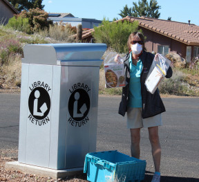 Clarkdale resident, Linda Litchfield, utilizing curbside pick-up to get her reserved library items.