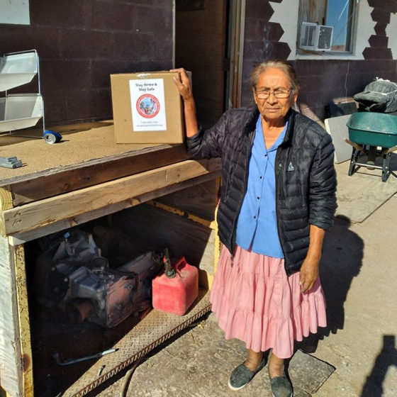 An elder Navajo woman receives an Isolation Kit to help prevent the spread of coronavirus within her community.