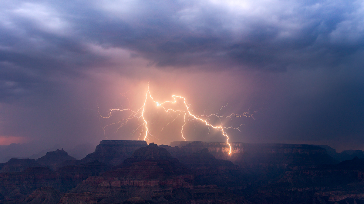 After sunset, a storm at the Grand Canyon sends out a lightning bolt that strikes down one of the canyon walls on August 17th, 2021