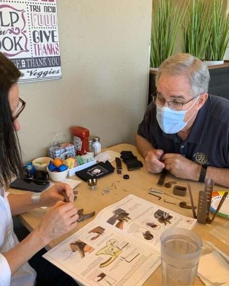 Club members John Lothrop and Danielle Giann working on a prosthetic hand kit.