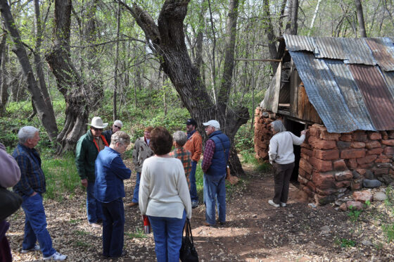 Tour attendees examine the Thompson springhouse on the Oak Creek Canyon