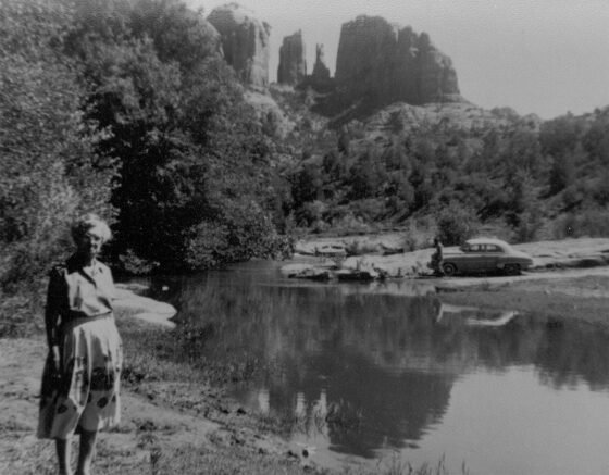 Addie Nininger stands near Red Rock Crossing on Oak Creek below Cathedral Rock as a vehicle prepares to traverse the low water crossing which once existed in the area.